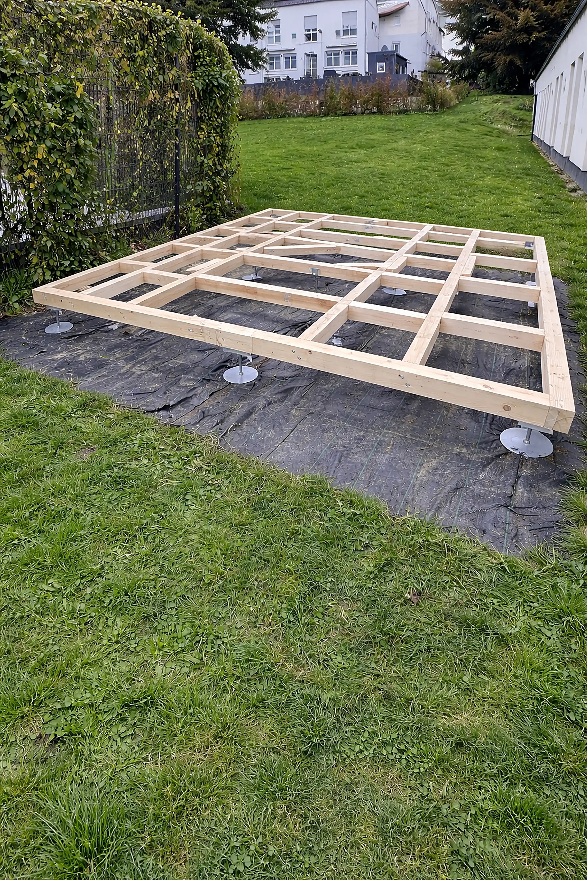 Logfoot-Fundament aus Holzbalken auf Schraubfüßen für ein Gartenhaus